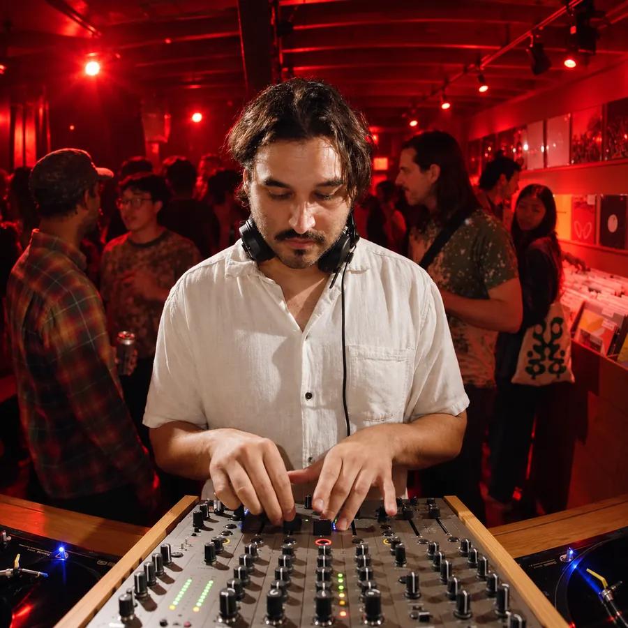 An artist at the mixer under red club light