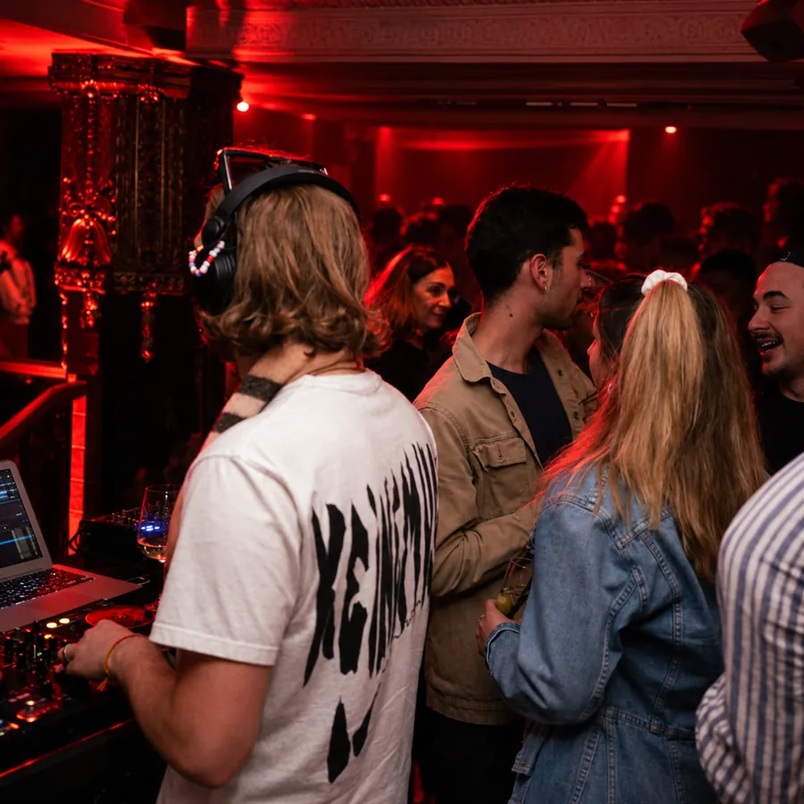 Fans in a red-lit room, one wearing headphones